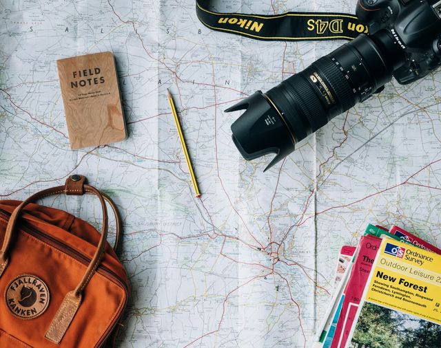 Map, notebook, and pencil laid out in quiet preparation